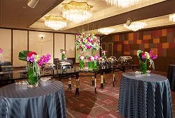 色鮮やかな花々で華やかに装飾された、ホテルの立食ビュッフェパーティー会場。