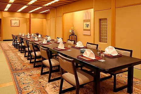 「京料理 たん熊 北店」の個室。畳敷きに絨毯が敷かれ、長いテーブルに椅子席が並ぶ、上品で落ち着いた和風の座敷です。