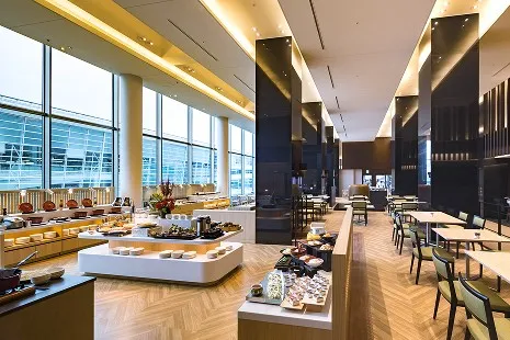 コスモスの内観。大きなガラス窓に面した開放的な店内に、彩り豊かなビュッフェ料理が美しく並ぶ様子。