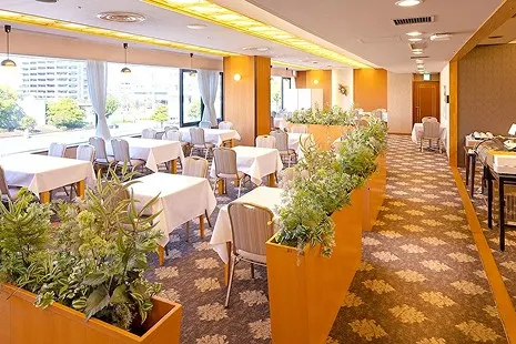ル・パラディの内観。大きな窓から光が差し込む明るい店内に、白いテーブルクロスが敷かれた席が並ぶ様子。