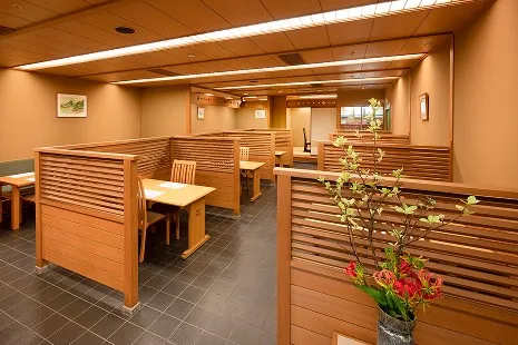 日本料理「有楽」の内観。木目調のパーテーションで仕切られた、落ち着いた雰囲気のテーブル席。